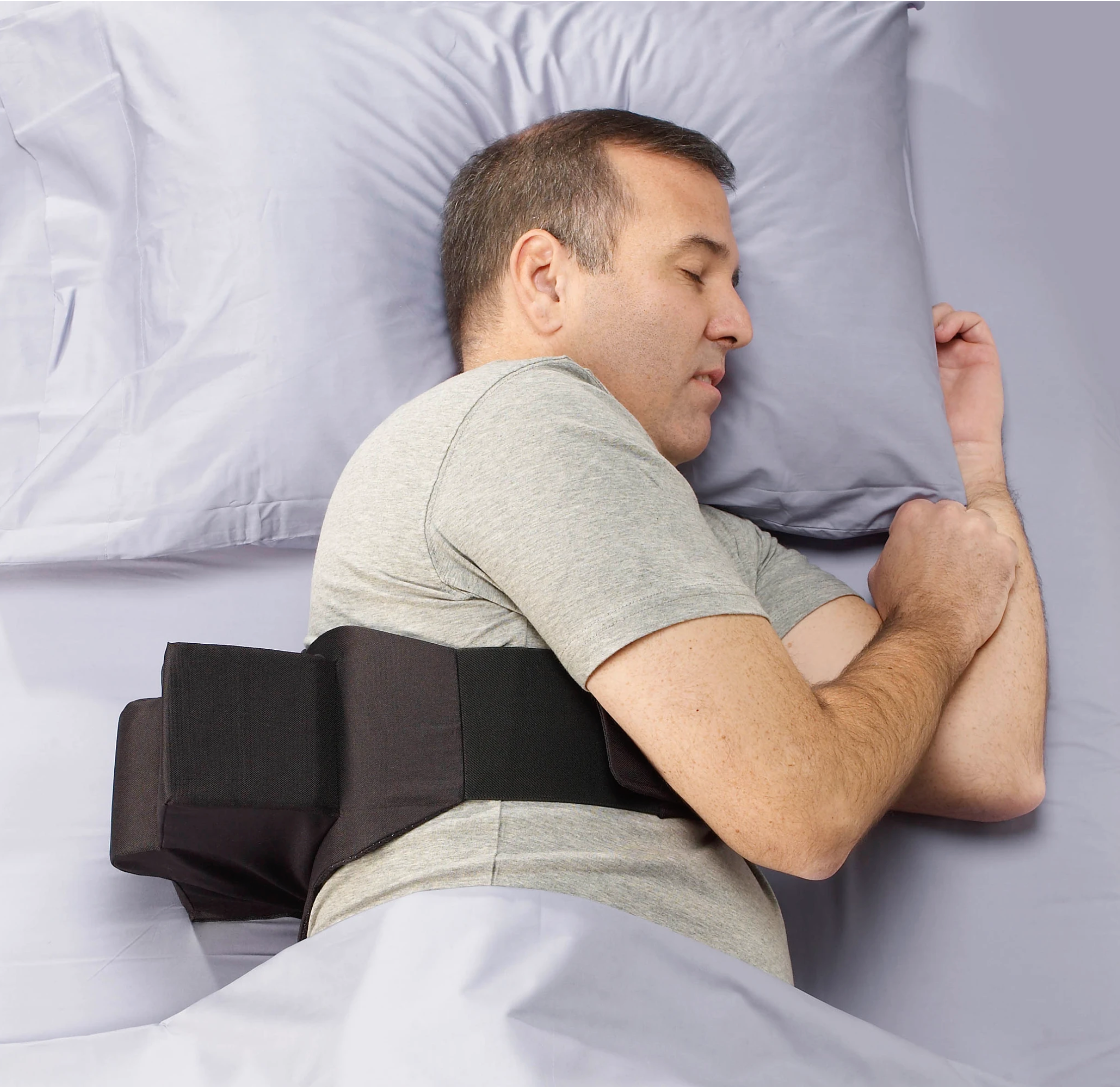 An image of a person lying on their left side, wearing the Zzoma positional sleep device for OSA & snoring.