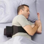 An image of a person lying on their left side, wearing the Zzoma positional sleep device for OSA & snoring.